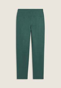 Pantaloni aderenti di un verde scuro con vita elastica, distesi su uno sfondo chiaro, senza tasche o decorazioni visibili.