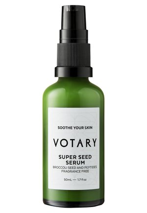 Bouteille en verre vert de Votary Super Seed Serum avec un pulvérisateur noir. L'étiquette présente un fond blanc avec un texte noir et des motifs géométriques.