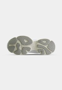 White sneaker outsole with textured grey rubber in intricate patterns. Features rounded edges and a smooth, lightweight construction.