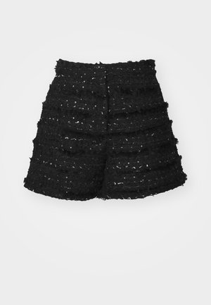 Svarta texturerade shorts med lager av tyg och fransade kanter; prydda med paljetter som skapar en subtil glans.