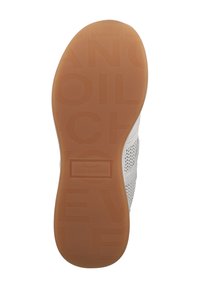 White sneaker with a perforated upper, rubber sole, and embossed branding. The sole features a light brown, textured surface.