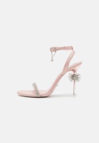 Lyserød højhælet sandal med en enkelt krystalbesat rem, justerbar ankelrem og en gennemsigtig stiletthæl med et dekorativt accent.