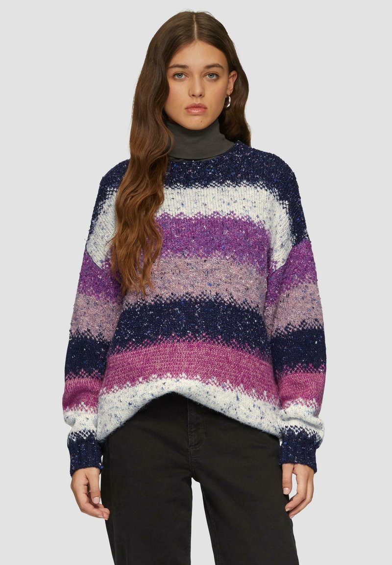 Sweter z dzianiny z wyraźnymi poziomymi pasami w kolorze granatowym, purpurowym i białym, o luźnym kroju i teksturowanej przędzy. Wysoki dekolt, długie rękawy.