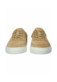 Een paar lichtbruine suède sneakers met witte rubberen zolen, vooraanzicht, met veters en het "BLACKSTONE"-merk op de tonglabels.