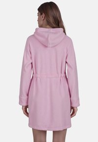 Huva pink badrock i mjuk fleece, med knytliv, långa ärmar och avslappnad passform, med en slät yta och inga synliga mönster.