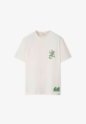 Wit T-shirt met korte mouwen met een groene afbeelding van een vis die in een stoel ligt met een glas in de hand, en een groen oceaangalmpatroon bij de zoom.