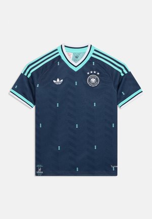 Tummansininen Saksan jalkapallopaita vaaleansinerein yksityiskohdin, Adidas-logo, kolme raitaa hartioilla ja joukkueen vaakuna neljällä tähdellä yläpuolella.