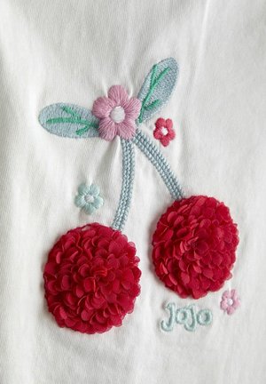 Dwa czerwone wiśnie z fakturą, z haftowanymi jasnoniebieskimi szypułkami, różowymi i czerwonymi kwiatami, zielonymi liśćmi oraz napisem „JoJo” na białej tkaninie.