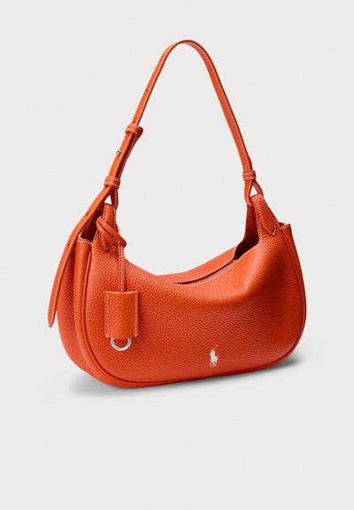 Sac à main en cuir orange de forme arrondie, à bandoulière unique et fermeture éclair. Comprend une petite étiquette et un accent logo. Surface texturée.