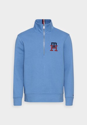 Blauwe half-zip sweatshirt van een katoenmix, met ribbelkraag en -manchetten, voorzien van geborduurd logo in rood en marineblauw. Gladde textuur.