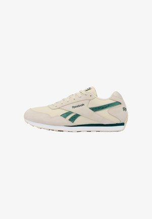 Beige en groene Reebok sneaker met suède panelen, groene gestructureerde strepen, witte zool en vetersluiting, zijaanzicht.