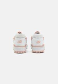 Weiße und hellrosa Turnschuhe mit einem Obermaterial aus glattem Leder, strukturierten Akzenten und einem gepolsterten Kragen. Mit dem New Balance-Logo an der Ferse.