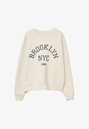 Krémový sveter s okrúhlym výstrihom, spadnutými ramenami a tmavo námorníckym textom s nápisom "BROOKLYN NYC 1898" v architektonickom dizajne.