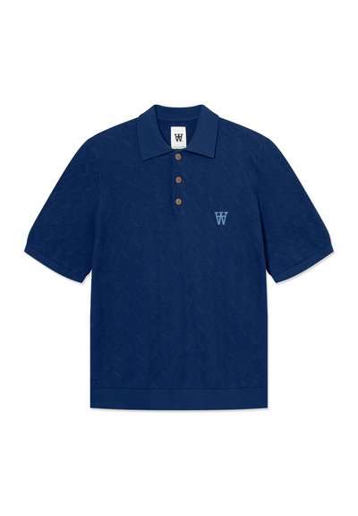 Polo bleu marine en tissu texturé. Présente un motif en losanges, trois boutons marron, et un logo brodé bleu clair.