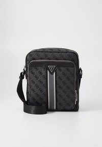 Bolsa mensajera de tela negra con patrón de logo, bolsillo delantero con cremallera, detalle de franja plateada, correa ajustable y parche de logo triangular.