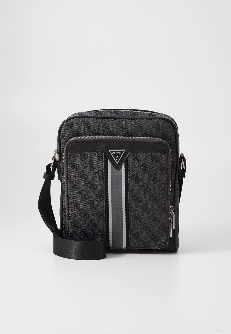 Bolsa mensajera de tela negra con patrón de logo, bolsillo delantero con cremallera, detalle de franja plateada, correa ajustable y parche de logo triangular.