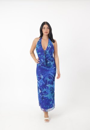 Abito lungo floreale blu con scollo halter, caratterizzato da un decolleté profondo e dettagli con fiocco, realizzato in un materiale leggero e dalla texture morbida.