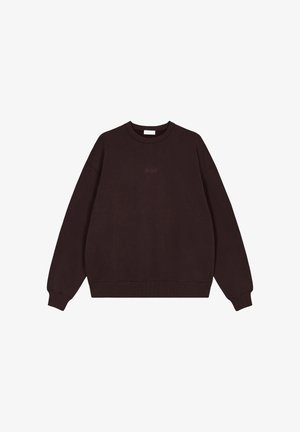 Felpa marrone scuro con collo rotondo, maniche lunghe e polsini a coste. Il materiale sembra morbido con dettagli minimi e un piccolo logo al centro.
