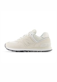 White suede sneaker with textured paneling, lace-up design, prominent 'N' logo, and gray rubber sole. Features smooth accents and subtle patterns.
