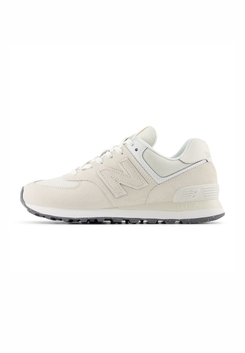 White suede sneaker with textured paneling, lace-up design, prominent 'N' logo, and gray rubber sole. Features smooth accents and subtle patterns.