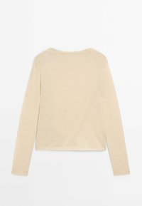 Beige long-sleeve top, soft texture, rounded neckline, cropped length, clean design, with no visible patterns or embellishments.