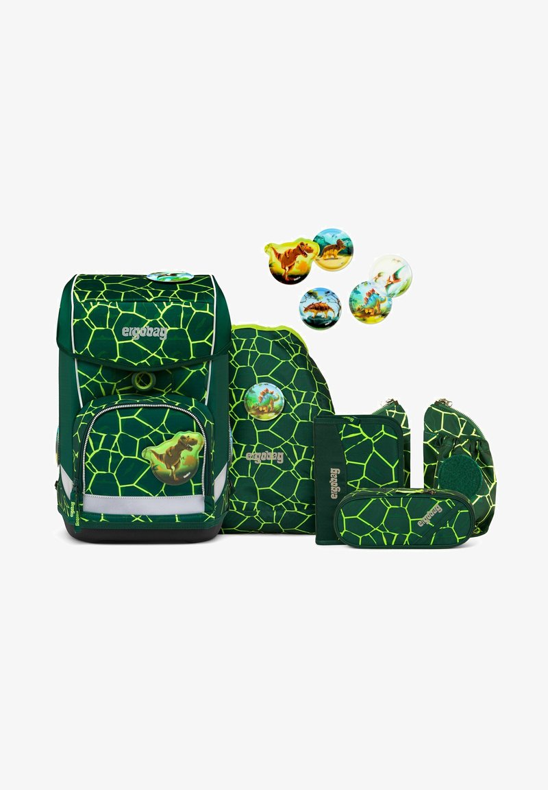 Grünes Rucksackset mit einem hexagonalen Muster, bestehend aus einem Hauptrucksack, kleineren Taschen und dekorativen Knöpfen mit Dinosauriermotiven.