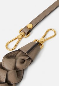 Geflochtener Lederriemen in Taupe mit goldenen Beschlägen. Verfügt über ein schlankes Design, einen Schnapphakenverschluss und eine strukturierte Oberfläche für Langlebigkeit.