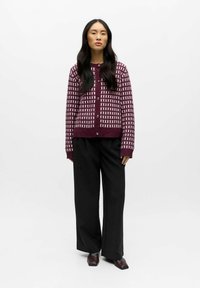 Burgundy stickad cardigan med ett geometriskt mönster, med rund halsringning, långa ärmar, knappstängning fram och ribbade muddar, som matchas med vida svarta byxor.