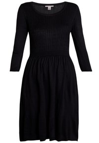 Robe noire avec une texture côtelée sur le corsage, des manches trois-quarts et une jupe évasée. Fabriquée en tissu tricoté doux.