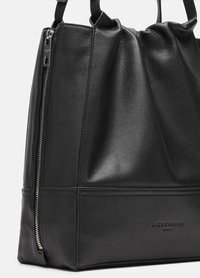 Sac fourre-tout en cuir noir avec une finition texturée, présentant un haut froncé, une fermeture éclair latérale et un logo de marque embossé à la base.
