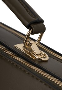 Brązowa skórzana torebka ma złoty zamek i okucia, z teksturowaną powierzchnią i wytrzymałym uchwytem.