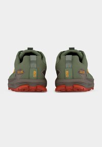 Ζευγάρι πράσινων και πορτοκαλί παπουτσιών trail running Gore-Tex, σε άποψη από πίσω, με τα ταμπελάκια στη φτέρνα να γράφουν "GTR" και ανθεκτικές κόκκινες σόλες.