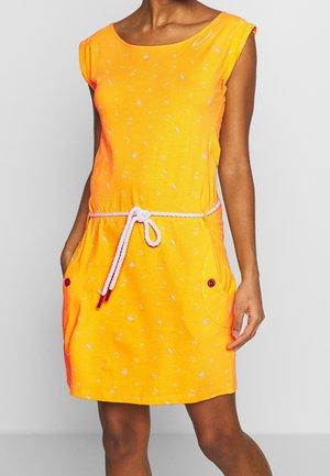 Ærmeløs, lys orange kjole med små hvide mønstre, hvidt reb bælte bundet i taljen og forlommer med røde knapper.