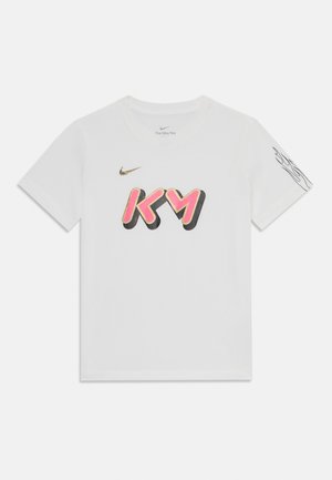 Wit Nike-T-shirt met roze en zwarte "KM" afbeelding op de voorkant, gouden Nike-logo erboven en zwart abstract lijnontwerp op de rechtermouw.