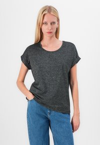 Black, short-sleeve t-shirt with a round neckline and a slightly textured, shimmering fabric. Paired with blue, high-waisted jeans.