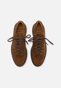 Bruine suède wandelschoenen met ronde veters, metalen oogjes en een gestructureerde zwarte rubberen zool, met een zachte binnenvoering.