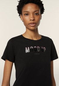 Camiseta negra con el texto "MOOD UP" en diseños metálicos y estampados. Mangas cortas, cuello redondo, confeccionada en suave material de algodón.