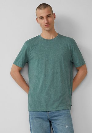 Groen gemêleerd katoen T-shirt met korte mouwen, ronde hals en een relaxed fit. Gecombineerd met lichtblauwe jeans met versleten details.