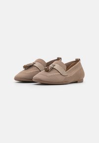 Mocasines beige con un tejido texturizado trenzado, que presentan un borlas decorativas y una banda de ante suave en la parte superior. Diseño de suela plana.