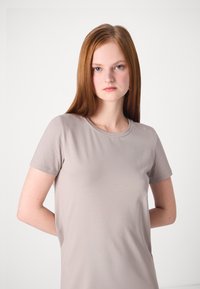 Ljusgrå kortärmad t-shirt i mjukt, slätt tyg med en klassisk rund halsringning och en avslappnad passform, med minimal sömdetalj.