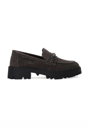 Mocassins en daim marron avec une semelle en caoutchouc noire épaisse, ornés d'une bride décorative et d'un accent métallique sur le dessus. Forme classique de mocassin.