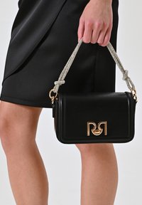 Zwarte leren handtas met een gouden logo, voorzien van een sprankelende zilveren kettingband, rechthoekige vorm en een gladde textuur.