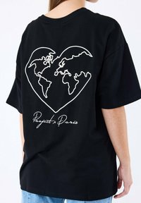Camiseta negra con un contorno blanco de un corazón que engloba un mapa del mundo, con el texto "Project x Paris" debajo del diseño.