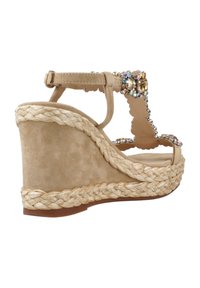 Sandalo con zeppa in suede beige, tacco in juta intrecciata, decorazioni con gioielli, cinturino alla caviglia e design con bordo a ondine.
