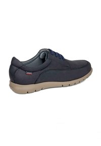 Zapatos azul marino con un upper sintético suave, acentuados por cordones azules y una suela de goma beige, que cuentan con un cuello acolchado para mayor comodidad.