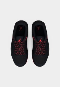 Μαύρα αθλητικά παπούτσια με κόκκινες λεπτομέρειες, με λεία υφή, στρογγυλεμένη μύτη και κορδόνια με σχέδια. Το λογότυπο είναι ορατό στη γλώσσα και στις εσωτερικές σόλες.