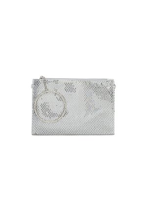 Pochette en maille argentée avec une bride circulaire pour poignet attachée à la fermeture éclair sur fond blanc.