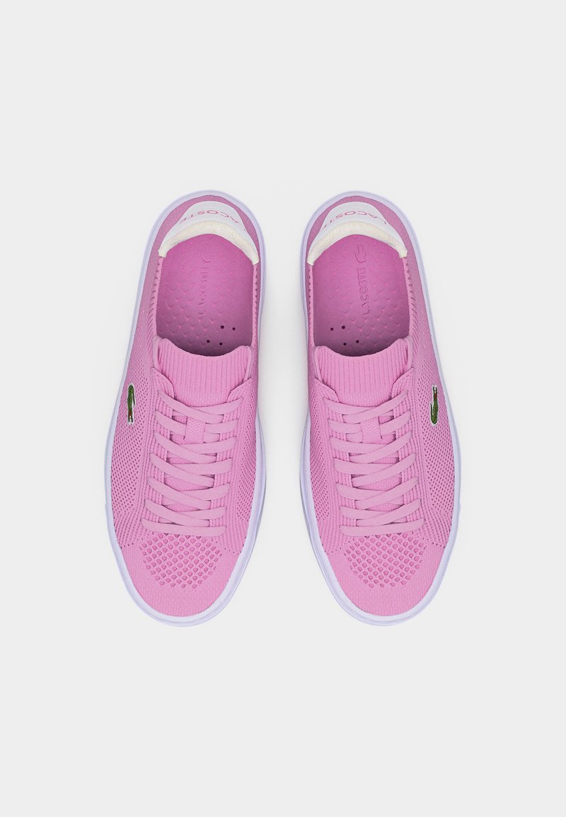 Paar pinker Lacoste-Sneaker mit weißen Sohlen und Schnürsenkeln, atmungsaktivem Strick-Obermaterial und grünem Krokodil-Logo an den Seiten.