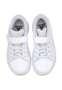 Zapatillas deportivas blancas con parte superior sintética suave, cierre de cordones y velcro, lengüeta acolchada y suela texturizada. El logo de Adidas es visible en el interior.