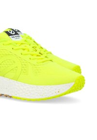 Scarpe da atletica giallo brillante con una tomaia in rete, suola testurizzata e intersuola variopinta. I lacci e il marchio neri completano il design.